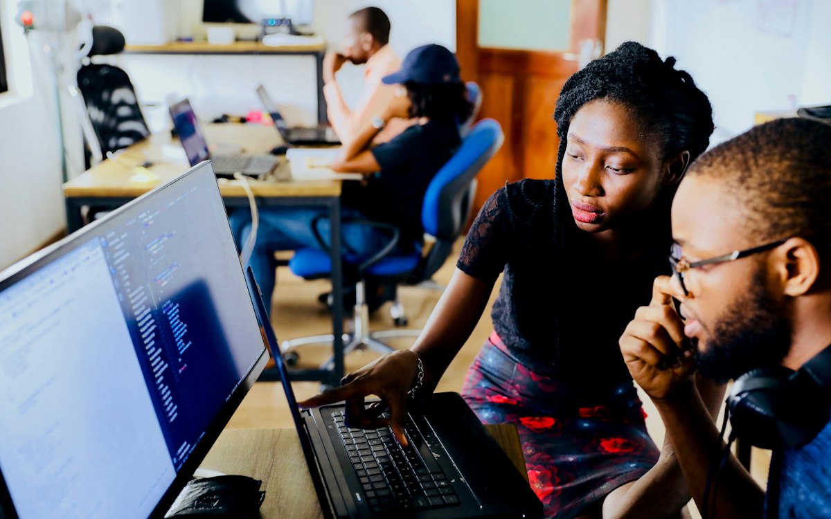 Two colleagues learning together at a computer.